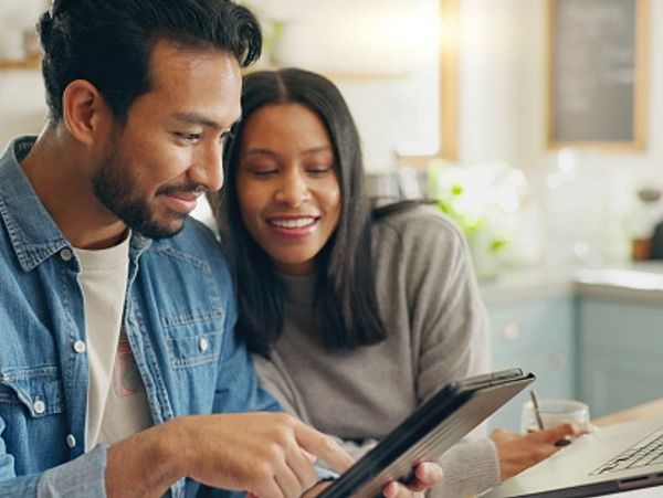 Couple using a tablet together in a cozy kitchen.