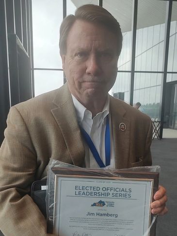 Man holding an award certificate indoors.