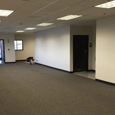 Empty office space with gray carpet and white walls.