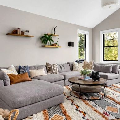 Modern living room with gray sectional sofa and patterned rug.