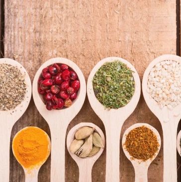 Wooden spoons filled with various spices and herbs.