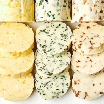 Three types of sliced herb-infused butter.