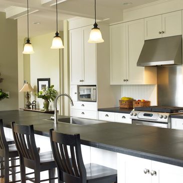 Modern kitchen with black countertop and white cabinets.