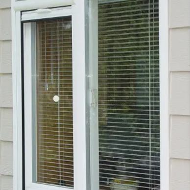White sliding glass door with blinds and beige siding.