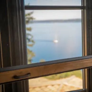 View of a calm lake through a wooden window frame.