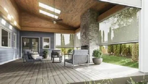 Spacious covered patio with seating and a stone fireplace.