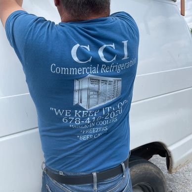 Technician wearing a CCI Commercial Refrigeration shirt fixing a white van.