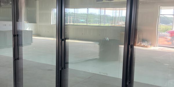 Empty room with glass sliding doors and outdoor view.