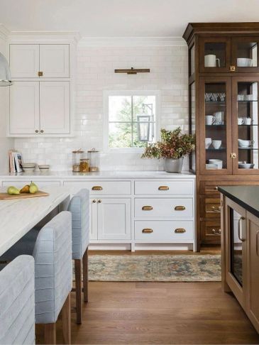 Bright kitchen with white and wood cabinets and a small window.