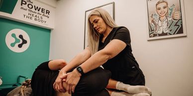 A therapist performing a stretching exercise on a patient in a clinic.