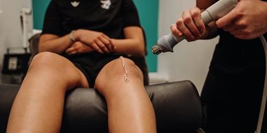 Person receiving a knee treatment with a medical device.