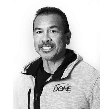 Man smiling in a black and white portrait wearing a hoodie with Dome logo.