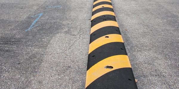 Caution wrapped black and yellow speed bump install for traffic control bolt down. 
