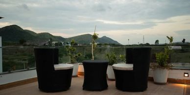 Outdoor seating area with black chairs and mountain view.