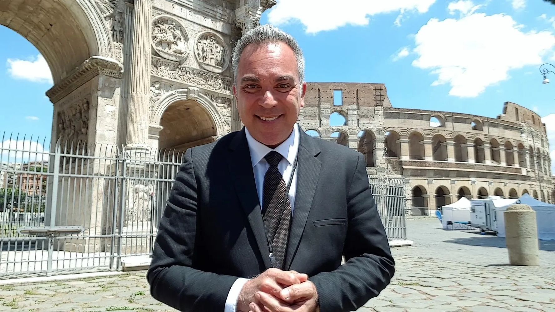 Repórter Mauro Beni entre o Coliseu e o Arco de Costantino em Roma para gravar reportagem.
