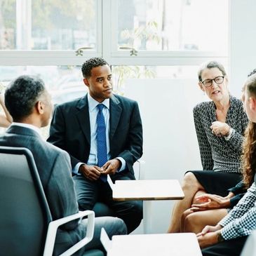 Business group engaged in a discussion in a modern office.