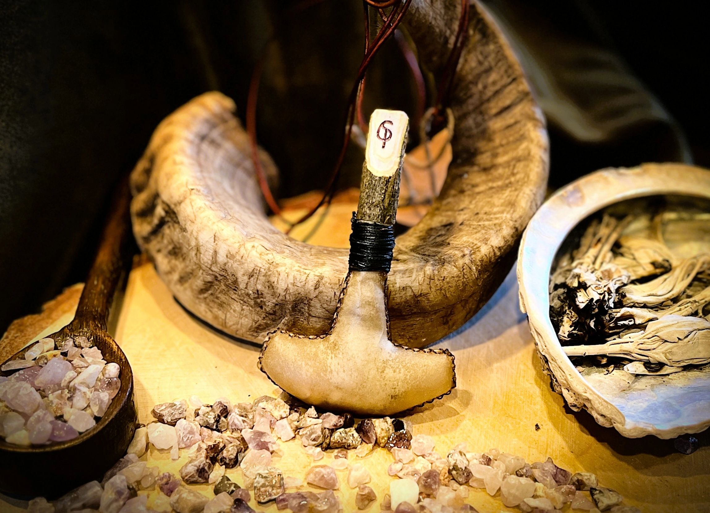 Image of the Mjolnir shaped Hand rattle. Hammer shaped deer hide rattle on an ash peg with Sigil