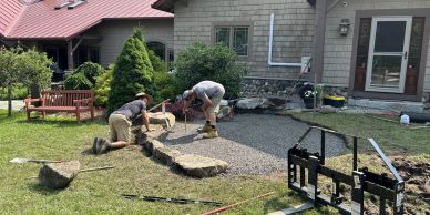 Two men laying flagstones for a pathway.