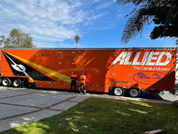 Picture of an orange color truck and two men are standing there