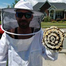 Friendly service technician smiling while holding hive