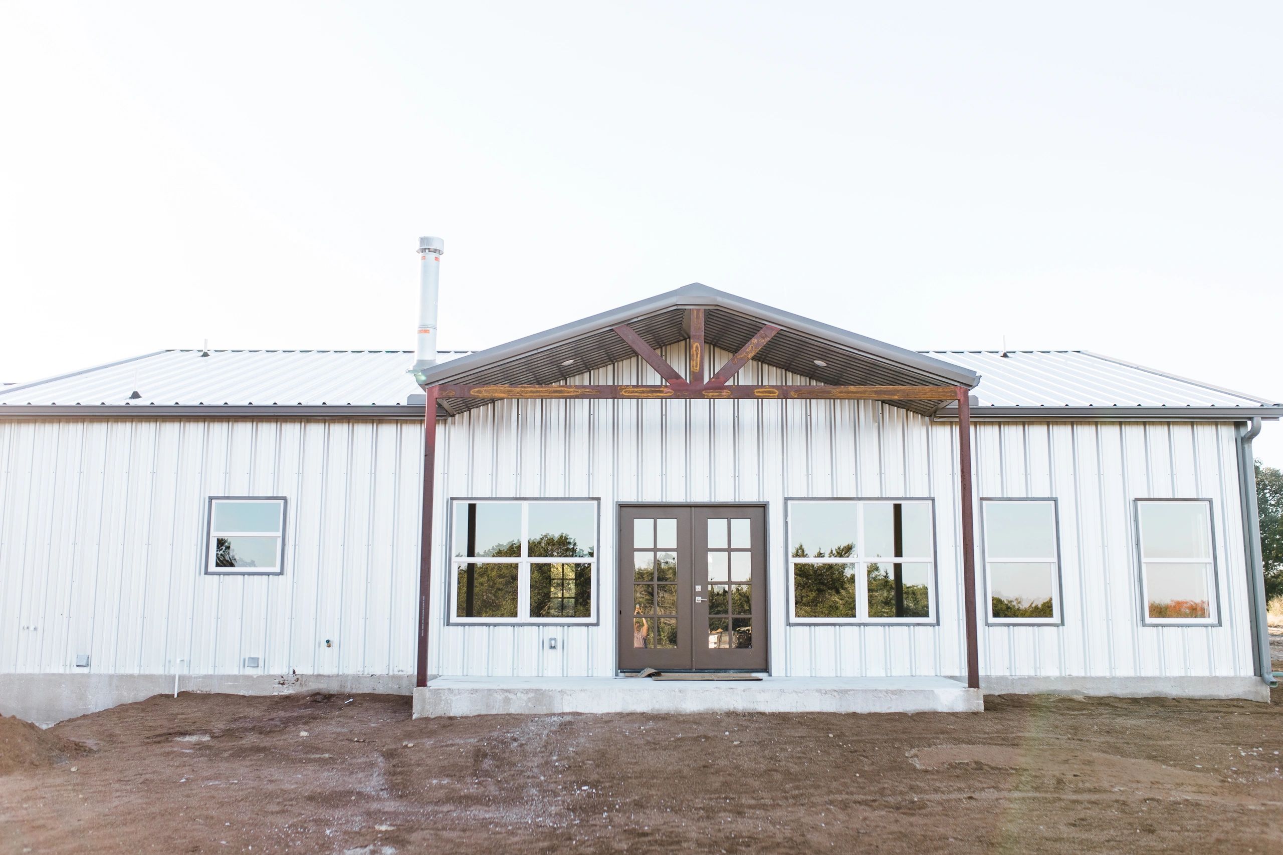 Modern metal building with large windows and double doors.