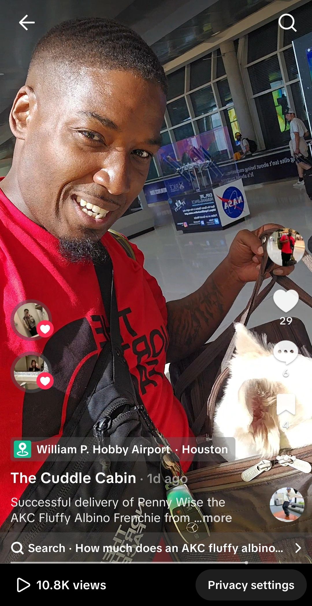 Man smiling with a fluffy albino Frenchie at an airport.