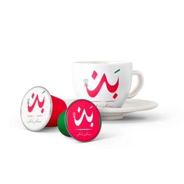 Coffee capsules and a white cup with Arabic script on a white background.