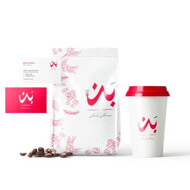 Coffee packaging and cup with Arabic branding and coffee beans.
