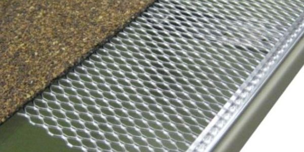 Metal mesh gutter guard installed on roof gutter to prevent debris.