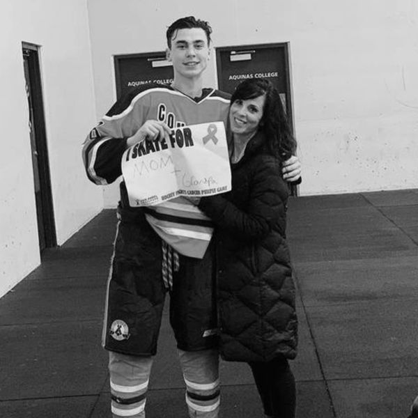 hockey player holding sign with adult woman