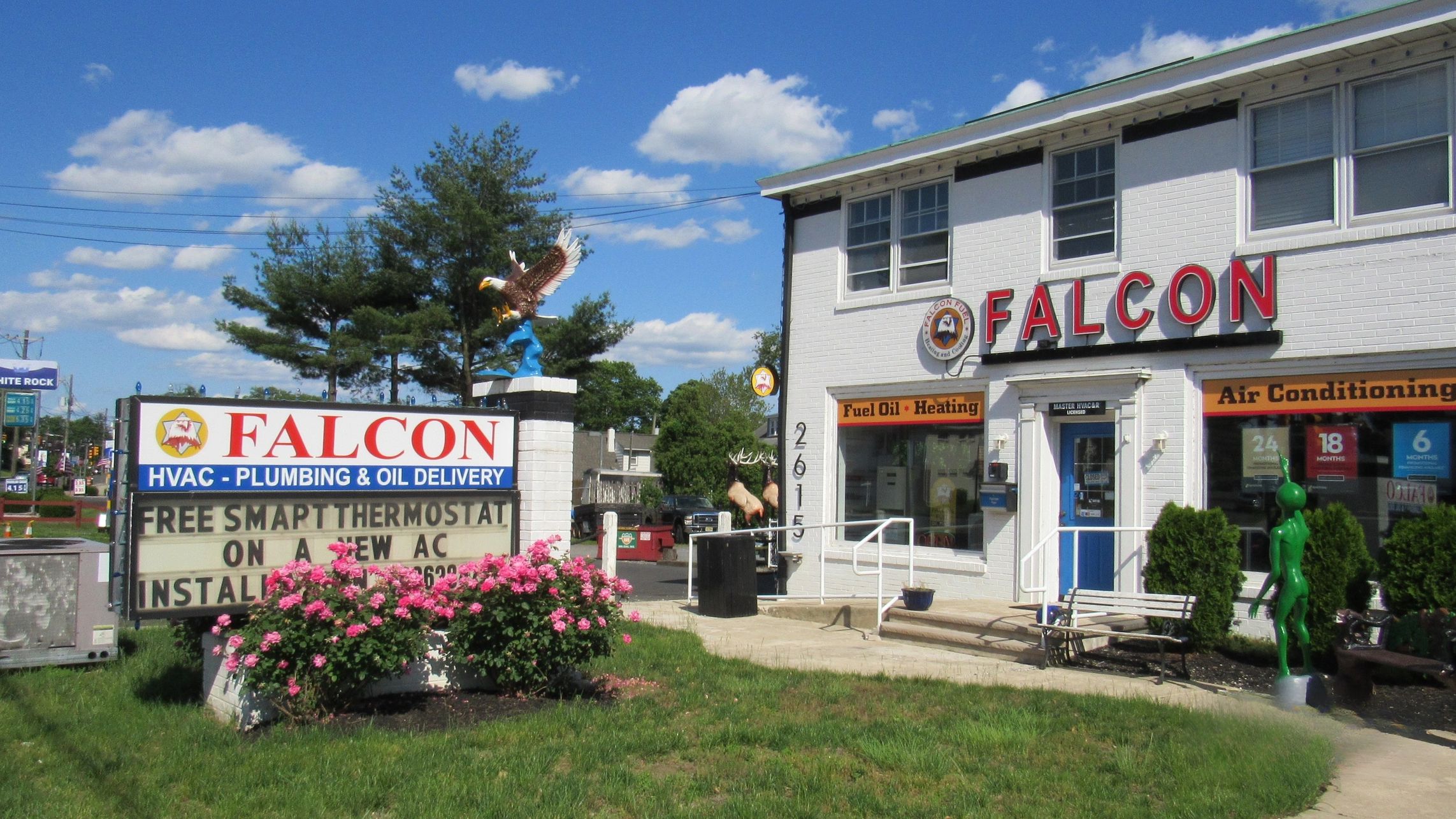 Falcon HVAC and plumbing business with eagle statue and flower bushes.