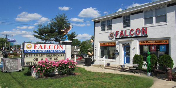 Falcon HVAC and plumbing service building with signage and flowers.