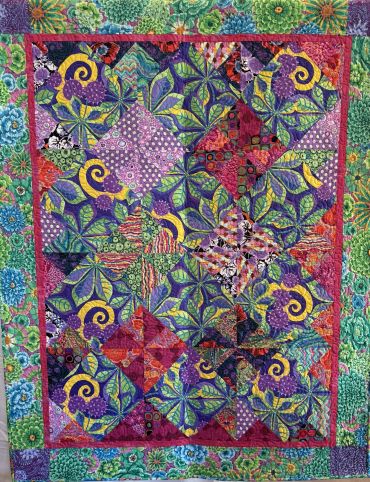 Colorful floral patchwork quilt with vibrant green border.