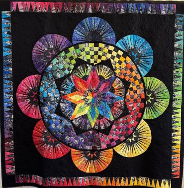 Colorful circular quilt with star and checkered patterns.