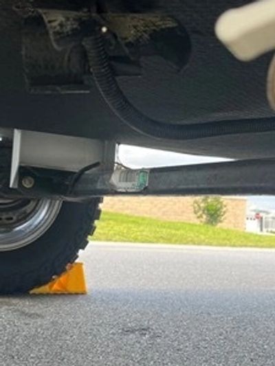 Truck tire secured with a yellow wheel chock.