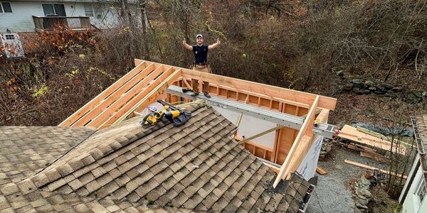 Man celebrating on construction roof frame.