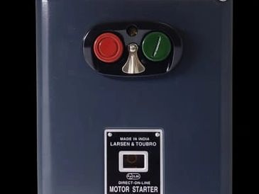 Close-up of a Larsen &amp; Toubro motor starter with red and green buttons.