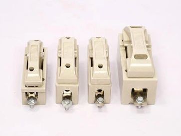 Four beige electrical fuse holders of varying sizes lined up.