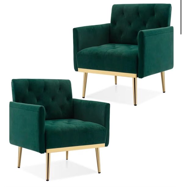 Two green velvet armchairs with gold legs and tufted backs.