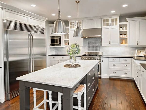 Modern kitchen with white cabinets and a marble island.