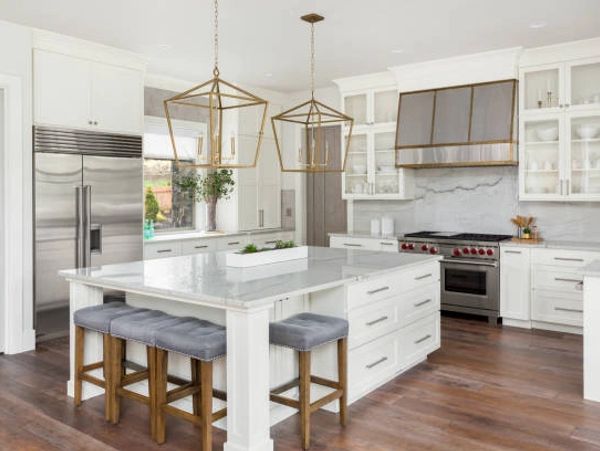 Bright modern kitchen with white cabinetry and marble countertops.