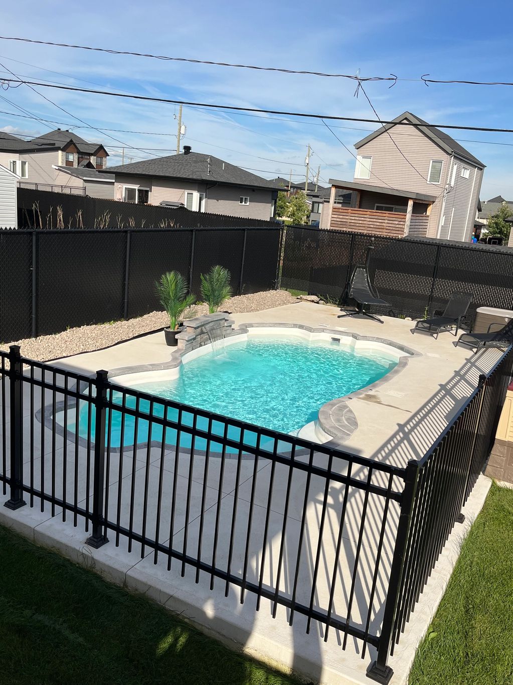 piscine atypique fibre de verre installée et aménagée pierre de couronnement béton blanc et clôture 