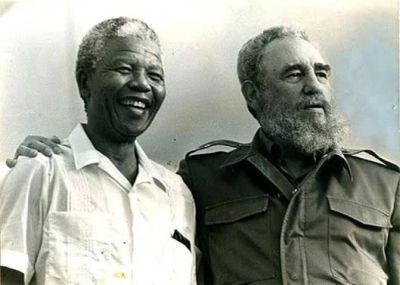 Two men smiling, one in casual clothes and the other in military attire.