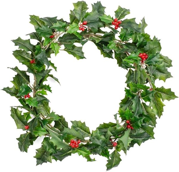 Green holly wreath with red berries on a white background.