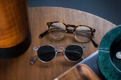 A pair of sunglasses and clear on a wooden table