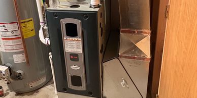 Indoor HVAC furnace and water heater setup in a basement.