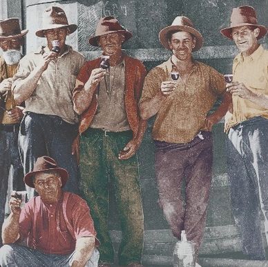 Group of men in hats holding drinks, posing together outdoors.