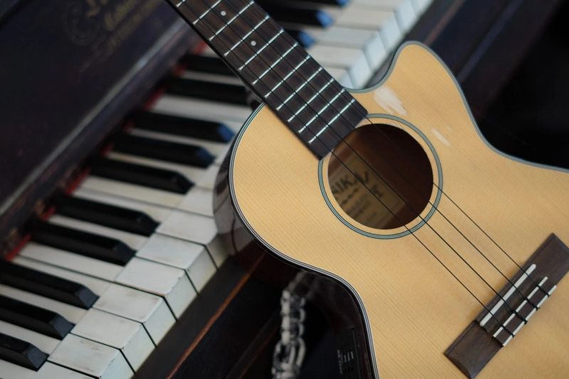 Ukulele resting on piano keys