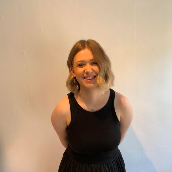 Young woman smiling in a black dress.