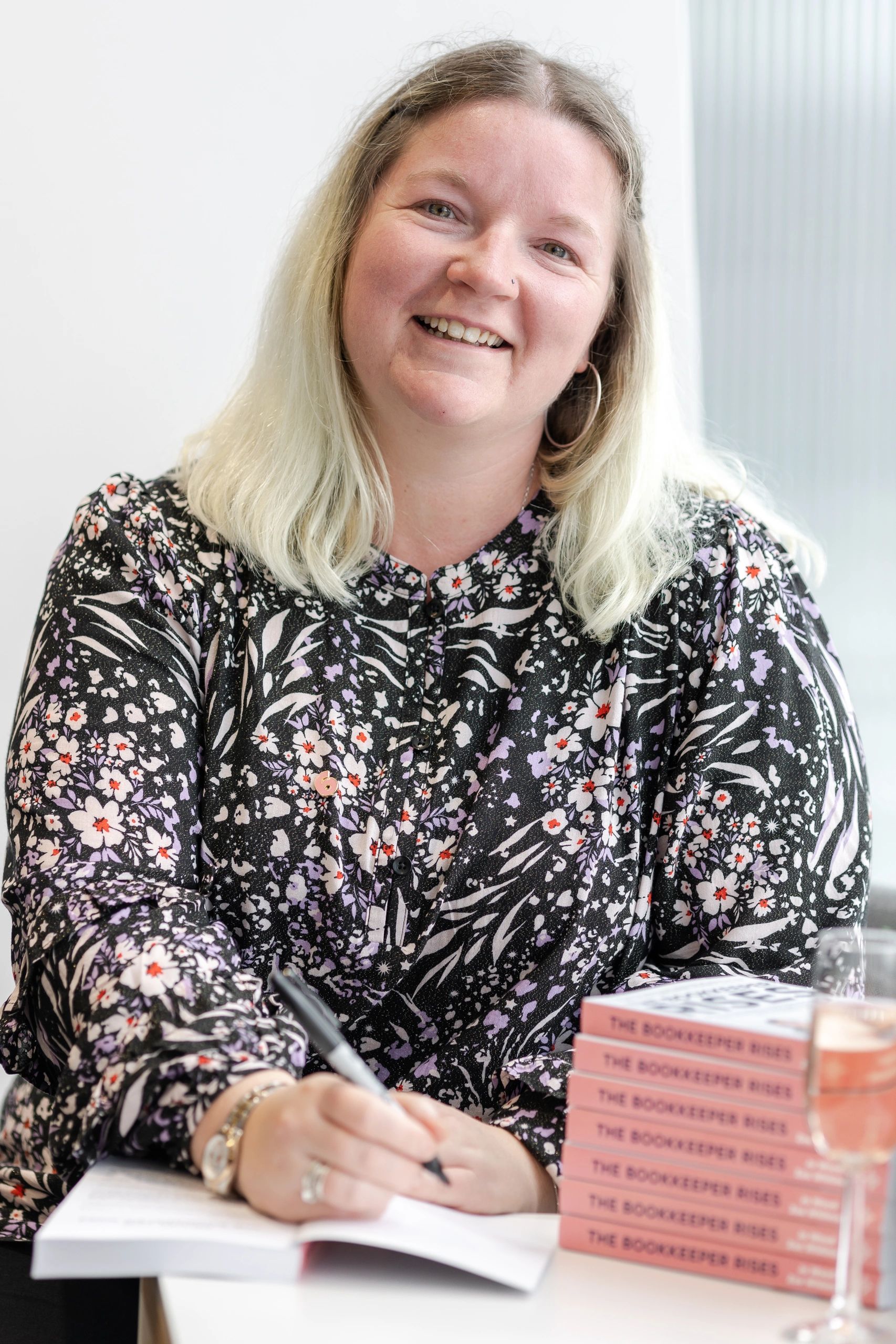 Sarah Kitchener sat smiling at the camera signing The Bookkeeper Rises book at The Shard, London